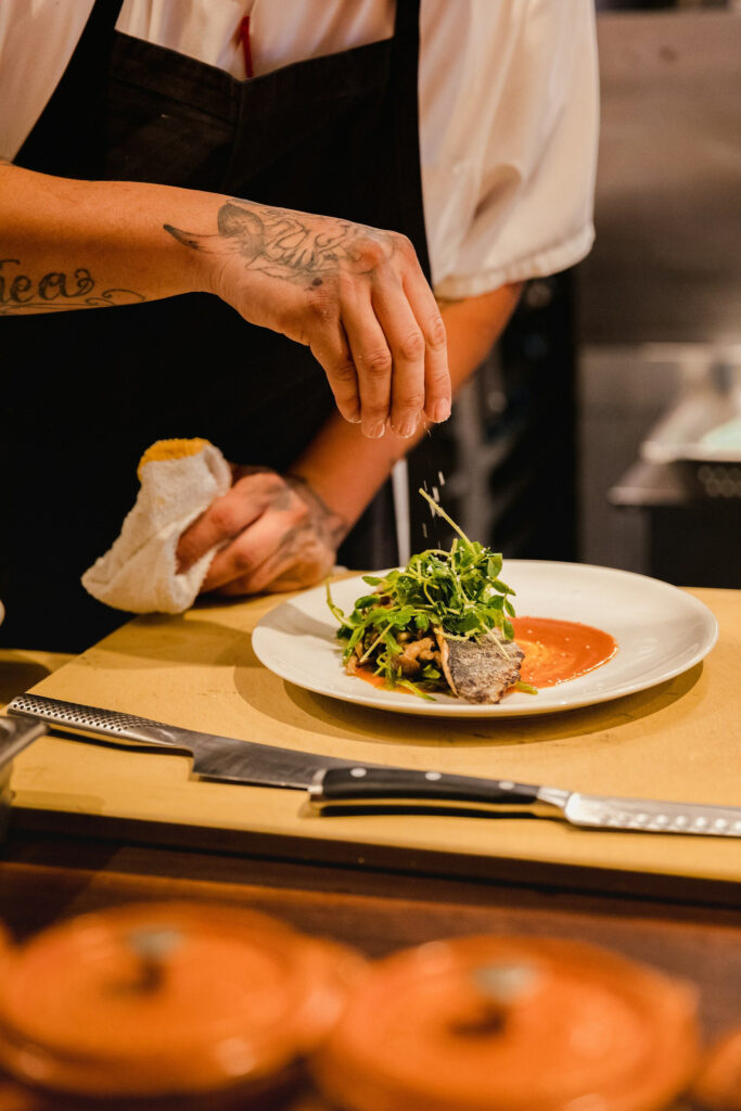 Rlt cuisine chef plating a course in the kitchen at playa potrero, guanacaste.